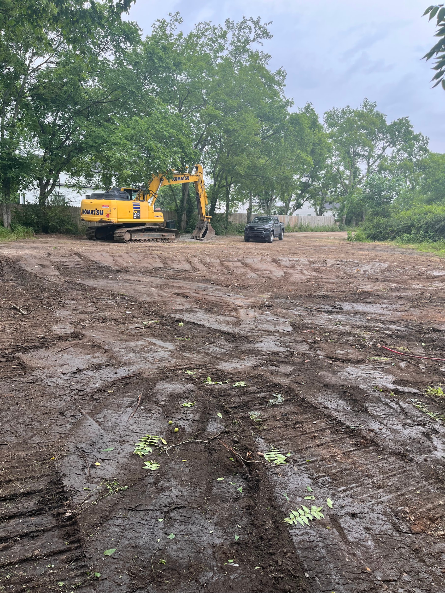 Cleared and graded lot at 616 W Green Lane with excavator on site